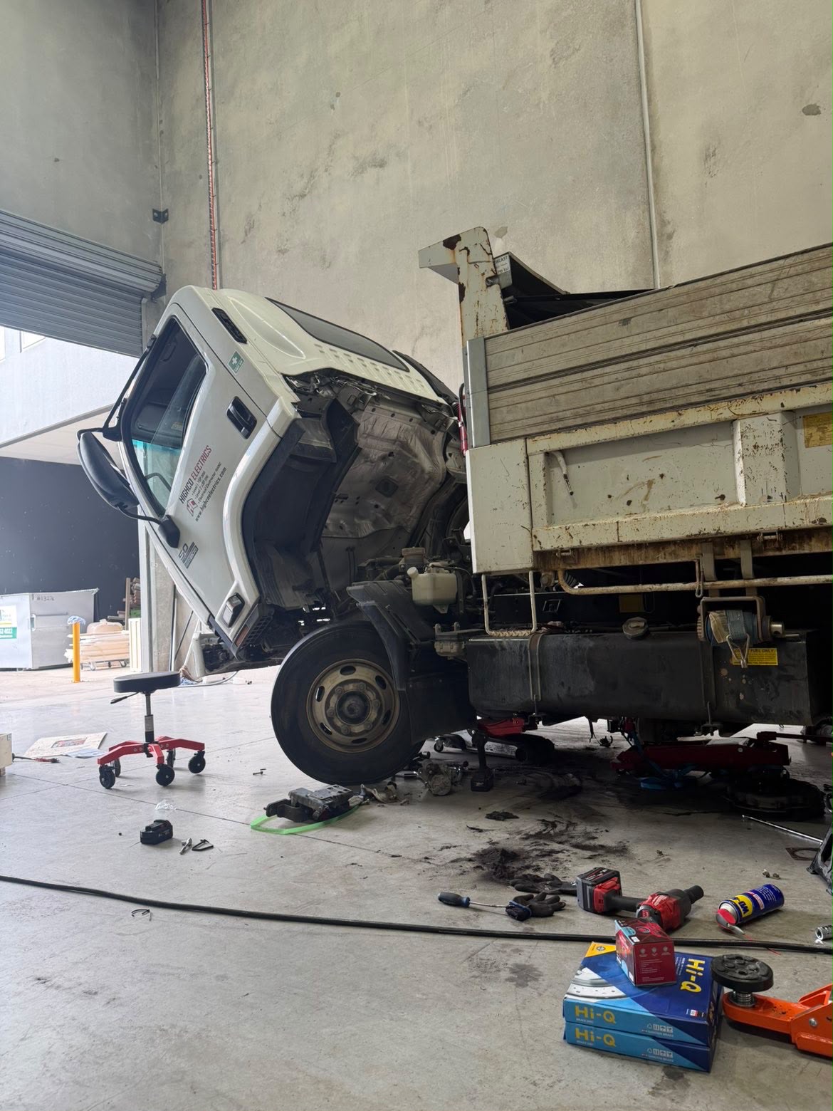 Tipper truck with cab tilted forward for engine access